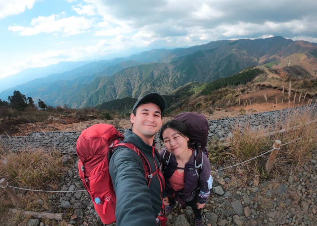 Hiro and Nomin taking a selfie with mountains in back.