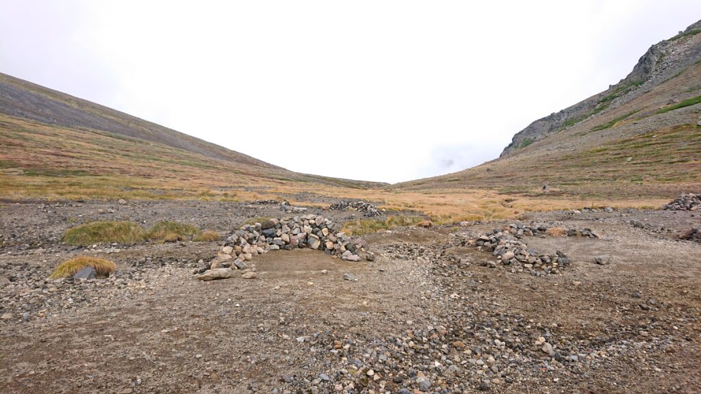 Public area for camping with some low walls made by rocks