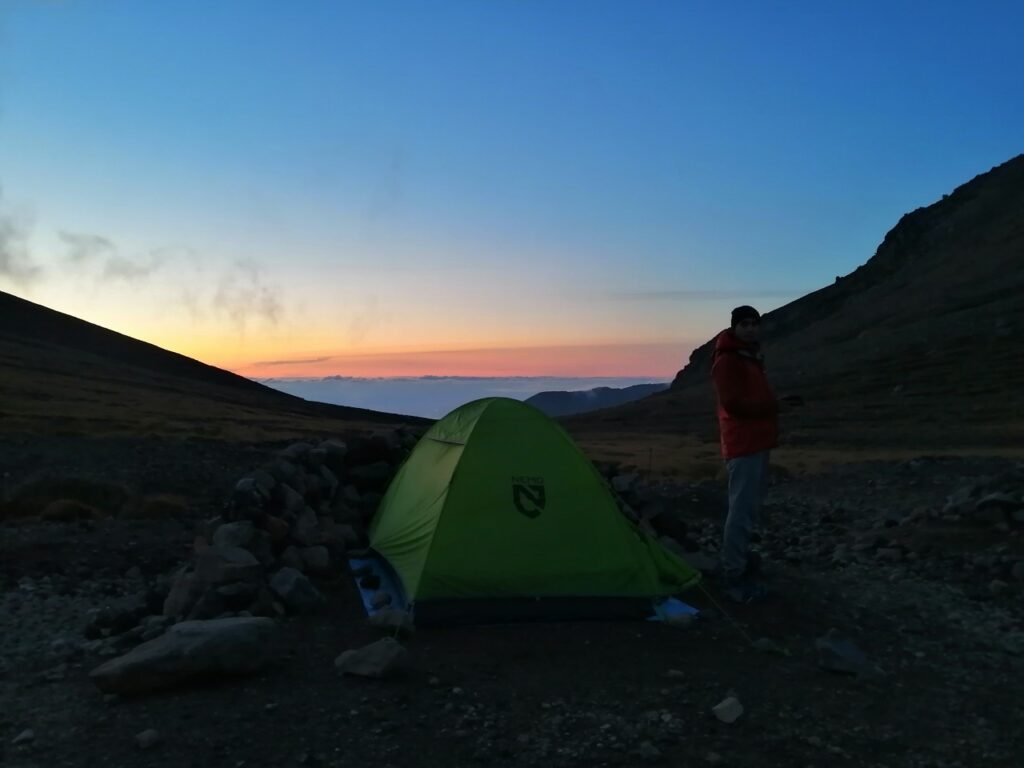 Public camping area at sunset, with a tent in the middle